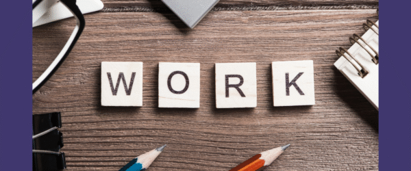 Work spelt out on a desk using tiles with usual work related paraphernalia such as pencils, notepads in shot