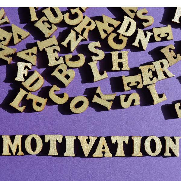 Image showing wooden letters scattered across purple background with word motivation spelt underneath.