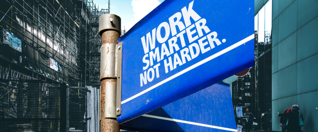 Blue sign saying work harder not smarter on the background of commercial buildings including scaffolding